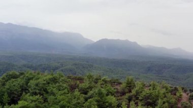Dokulu gökyüzü olan dağ manzarasının insansız hava aracı videosu. Dağ sıraları tepeleri ve kayaları olan ağaçlarla kaplıdır. Antalya Türkiye 'nin havadan görüşü. Yüksek kalite 4k görüntü