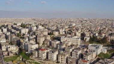 Şehrin Orta Doğu 'daki Arap tarzında insansız hava aracı videosu. Dağların yamaçlarında evleri ve caddeleri olan şehir manzarası. Hava manzaralı Amman Jordan. Yüksek kalite 4k görüntü