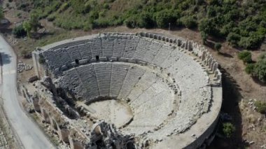 Drone video of the ruins of an ancient theater, the site of an archaeological site with a historic building. Aerial view Antalya Turkey. High quality 4k footage