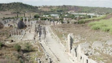 Tarihi bir yerin insansız hava aracı videosu. Antik bölgenin arkeolojik kazıları. Sütunları, evleri ve meydanları olan antik şehrin caddesi. Antalya Türkiye 'nin havadan görüşü. Yüksek kalite 4k görüntü