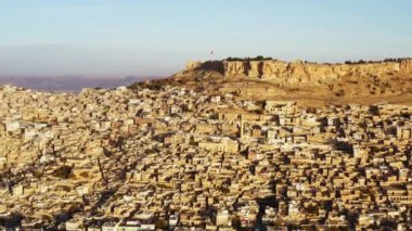 Drone video of a cityscape in a historic city on a rock in Misopotaya. Ancient houses and streets with Middle Eastern architecture. Aerial view Mardin Turkey. High quality 4k footage