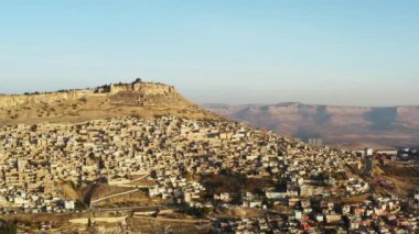 Şehrin kayanın üzerindeki insansız hava aracı videosu. Misopotamya 'da evleri, camileri ve caddeleri dağ sıraları ve kanyonları olan dağların altında güzel bir manzara..