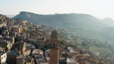 Drone video of the minaret of the mosque in the old town at sunrise. A beautiful city with Middle Eastern architecture in Misopotamia. Aerial view Mardin Turkey. High quality 4k footage