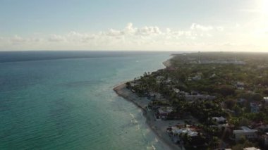 Drone video of a tourist shoreline in the Caribbean Sea. Hotels and sandy beaches by the sea in a beautiful landscape with palm trees and sand. Aerial view Playa del Carmen. High quality 4k footage