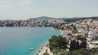 Hırvatistan sahili havacılık manzaralı. Adriyatik kıyısında kırmızı çatıları, plajları ve turistik yerleri olan bir kasaba..