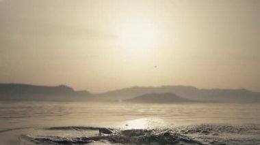 Saçına su sıçratan bir kızın yavaş çekim videosu. Kadınlar okyanusta yüzer ve yelpaze yapar. Yaz tatili neşesi ve rahatlama. Yüksek kalite 4k görüntü