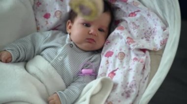 Küçük kız sallanan sandalyeye biniyor. Emzik sallanan bir çocuk sallanan bir sandalyede uyuyakalır. Çocukken yavaş çekim 4K videosu evde uyuyakalır. Yüksek kalite 4k görüntü