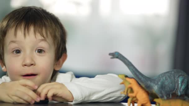 Happy Little Boy Playing Child Heals Dinosaur Toys Table Smiles — Vídeo de Stock