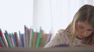 Deftere kalemle yazan bir kızın portresi. Salgın sırasında öğrenme, evde öğrenme, ders sırasında sosyal mesafe. Ödev yapan genç.