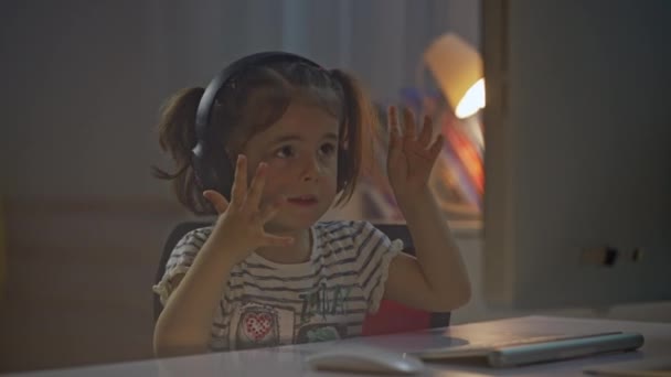 Маленькая Девочка Слушает Музыку Наушниках Перед Компьютером Внутренний Портрет Девушки — стоковое видео