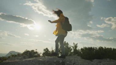 Kız dağ sırasının kayaları boyunca yürüyüş yapıyor. Dağ manzarasında turist yürüyüşü ve açık hava eğlencesi. Yüksek kalite 4k görüntü