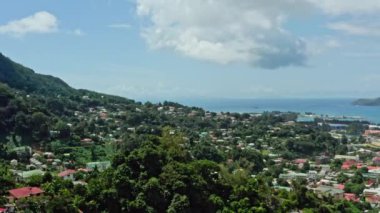 Aerial view of Mahe, Seychelles. Cityscape with houses and streets in the jungle on an island in the Indian ocean with exotic nature. High quality 4k footage