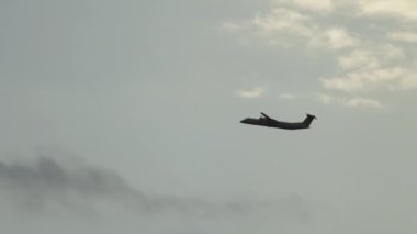 Silhouette of a plane flying in the sky. Slow motion video of the plane climbing up the mountain. High quality 4k footage