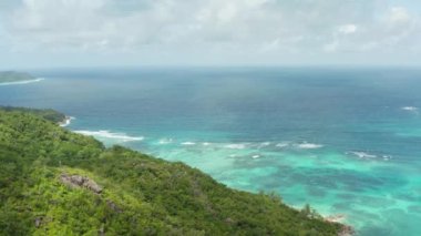 Aerial view nature of Seychelles. Coastline of the Indian Ocean with jungle and waves from the blue sea. High quality 4k footage