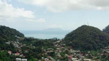 Aerial view of the island of Mahe, Seychelles. Mountain landscape on the shore of the Indian Ocean with rocks and jungle, houses and roads. High quality 4k footage