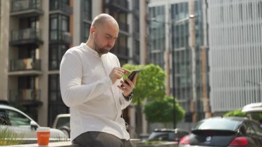 The manager, the man, corresponds on the phone, solves cases. A man with a serious expression on his face in casual clothes checks the stock exchange. High quality 4k footage
