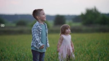 Happy smiling children bursting soap bubbles. Playing in the park at sunset. Slow motion video of a happy family. High quality 4k footage