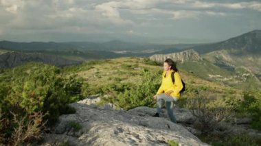 The girl climbs the mountains on rocks in a beautiful landscape. A woman on a hike, a trip to the mountains. High quality 4k footage