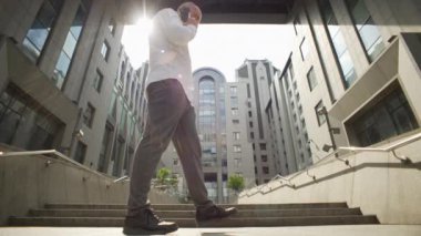 A businessman near the business center talks on the phone and solves cases. A serious man negotiates a contract on the device. High quality 4k footage