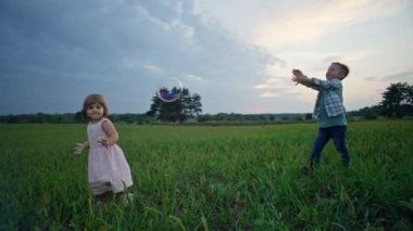 Çocuklar parkta birlikte sabun köpüğü patlattılar. Mutlu erkek ve kız kardeşler birlikte oynayıp, mutlu olurlar. Yüksek kalite 4k görüntü