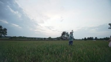 Parkta baloncukları patlatan bir çocuğun yavaş çekim videosu. Eğlenceli açık hava oyunları. Mutlu bir çocuk oynuyor. Aktif aile oyunları. Yüksek kalite 4k görüntü