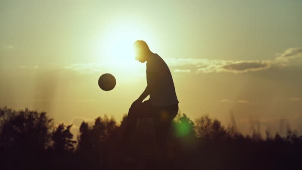 ボールを蹴っている男のシルエットのスローモーションビデオ サッカーの試合で路上でトレーニング 高品質4K映像 — ストック動画