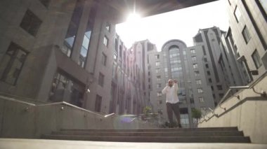 Takım elbiseli bir işadamı ofis binasından çıkarken telefonla konuşuyor. Ciddi bir adam iş merkezinden ayrılıyor. Yüksek kalite 4k görüntü