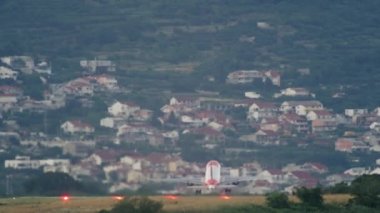 Uçak şehir manzarasının arka planına doğru havalanıyor. Turistli bir yolcu uçağı seyahate çıkıyor. Yavaş çekim videosu. Yüksek kalite 4k görüntü