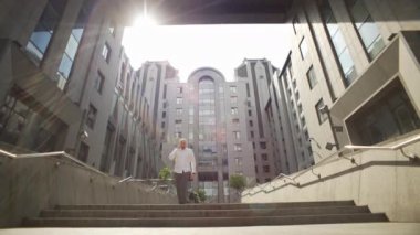 Bir iş adamı bir iş merkezinin arka planında yürür ve telefonda konuşur. Yönetici davaları çözer ve ortaklarla pazarlık eder. Yüksek kalite 4k görüntü