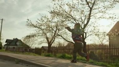 Kırsal alanda koşan çocuk. Baharda gün batımında gülümseyen mutlu çocuk. Yüksek kalite 4k görüntü
