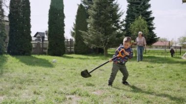 Çocuk annesinin bitki yetiştirmesine yardım eder. Aile işleri bahçede. Gezegeni küresel ısınmadan korumak. Yüksek kalite 4k görüntü