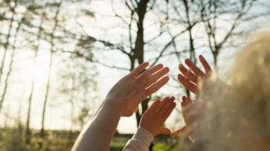 Anne ve oğul parmaklarıyla güneşe bakıyorlar. Mutluluk ve sıcaklığın video konsepti, ebeveyn sevgisi. Doğada çocukların mutluluğu. Yüksek kalite 4k görüntü