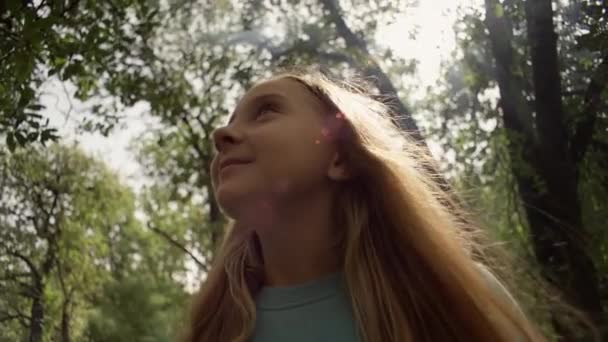 一个白人女孩在森林里的特写镜头一个孩子在大自然中做梦和微笑 森林里令人难以置信的气氛 高质量的4K镜头 — 图库视频影像