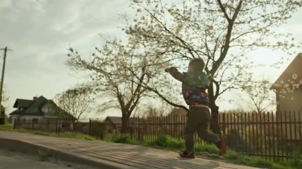 田園風景の中を走っている少年です 日没の春に幸せな笑顔の子供 高品質4K映像 — ストック動画