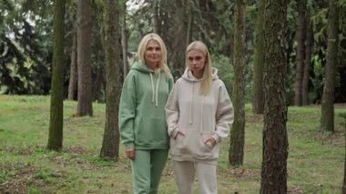 Moda kadınları kameraya bakıyor. Spor kıyafetleri giymiş son sınıf öğrencisi bir kadın. Parktaki açık hava kızı. Yüksek kalite 4k görüntü