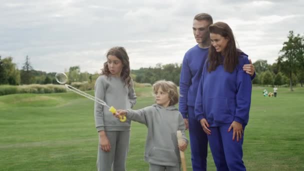 Bir Aile Parkta Yürürken Sabun Köpüğü Üflüyor Aile Mutluluğu Konsepti — Stok video