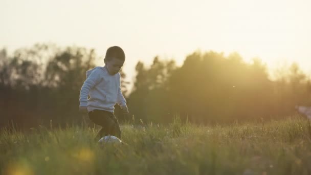 Ребенок Пинает Мяч Играет Футбол Закате Природе Счастливый Мальчик Тренируется — стоковое видео
