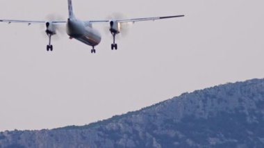 Uçak dağ manzaralı bir şekilde iniyor. Pervaneli bir yolcu uçağının yavaş çekim videosu. Yüksek kalite 4k görüntü
