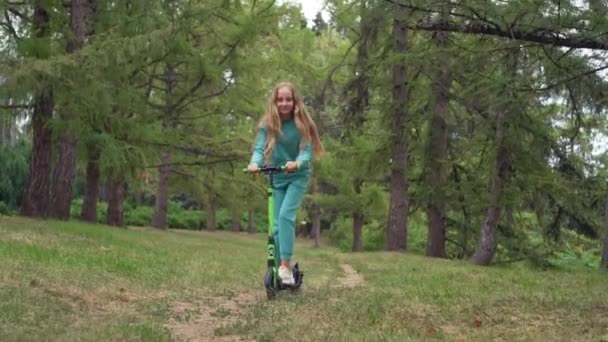 Дівчина Їде Скутері Парку Щаслива Дитина Посміхається Під Час Їзди — стокове відео