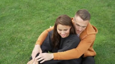 Yaz parkında bir kadına sarılan bir adamın yakın çekimi. Randevuda mutlu bir çift. Aile sıcaklığı kavramı, sevdiklerinin gülümsemelerinin mutluluğu. Yüksek kalite 4k görüntü