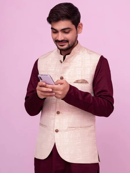亚洲的印度小男孩穿着传统服装 用智能手机发短信 面带微笑 — 图库照片