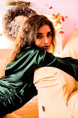 Noel ağacında elinde hediyeler ve şampanyayla genç bir kız..