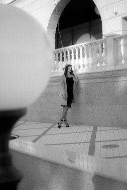 Black and white shot of a young girl walking around the city. The girl walks through the city to the store.
