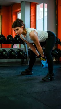 Spor salonundaki kız simülatördeki elleri çalıştırıyor.