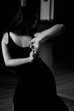 Kırmızı arka planda dans eden siyah dar takım elbiseli iki bale kızı.