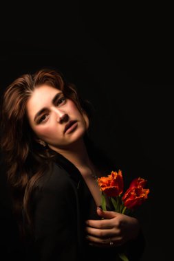 Siyah arka planda bir buket lalesi olan kız. Uluslararası Kadınlar Günü. Sevgililer Günü.