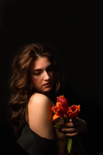 stock image girl with a bouquet of tulips on black background. International Women's Day. Valentine's Day.