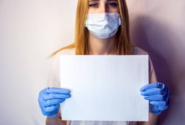 Yüzünde maske olan bir kızın elinde Covid19 işareti var. Beyaz arka plandaki bir kızın elindeki tablet. Elinde beyaz bir masa olan bir sarışın. Covid 19 yok. Elinde pankartla bir hemşire..