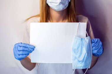 Yüzünde maske olan bir kızın elinde Covid19 işareti var. Beyaz arka plandaki bir kızın elindeki tablet. Elinde beyaz bir masa olan bir sarışın. Covid 19 yok. Elinde pankartla bir hemşire..