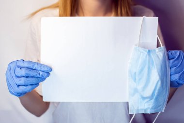 Yüzünde maske olan bir kızın elinde Covid19 işareti var. Beyaz arka plandaki bir kızın elindeki tablet. Elinde beyaz bir masa olan bir sarışın. Covid 19 yok. Elinde pankartla bir hemşire..